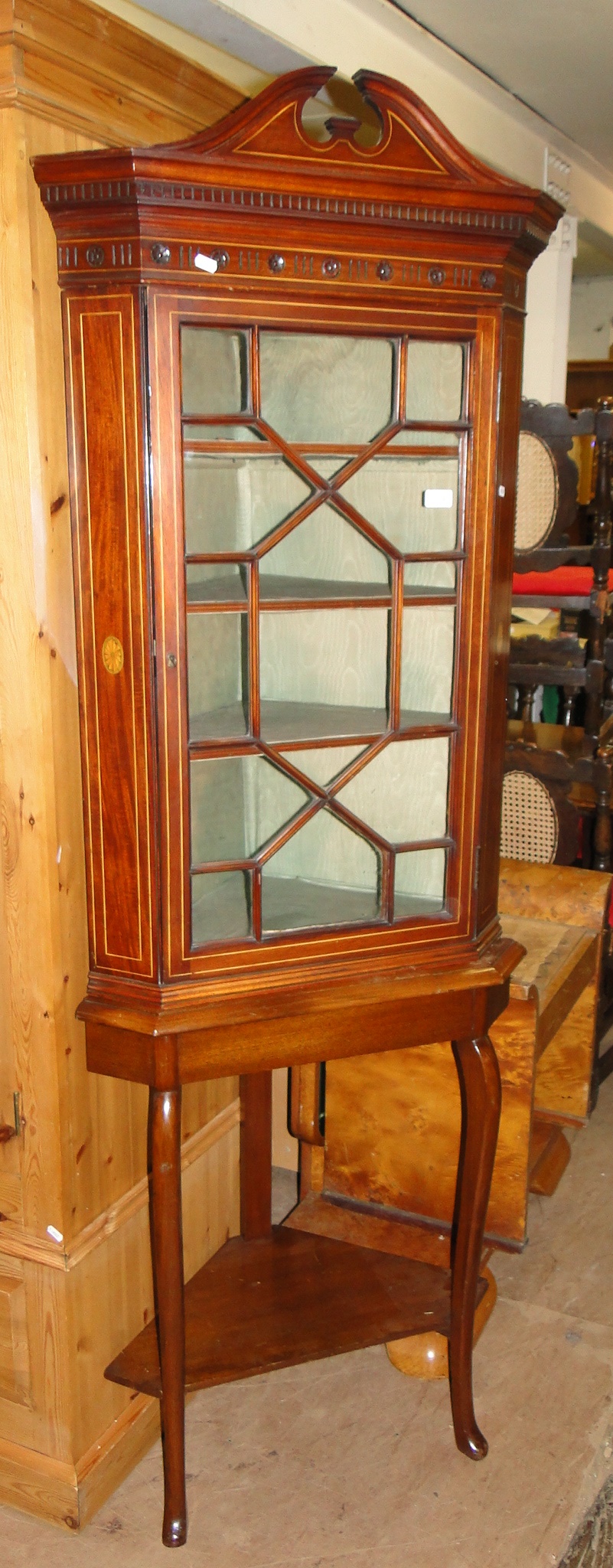 A mahogany and satinwood strung corner display cabinet on stand.