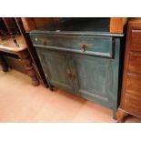 A painted cabinet with drawer and panelled cupboards under.