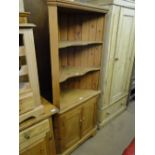 A floor standing pine corner cabinet with open shelves.