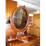 A Victorian mahogany oval swing toilet mirror on carved feet.