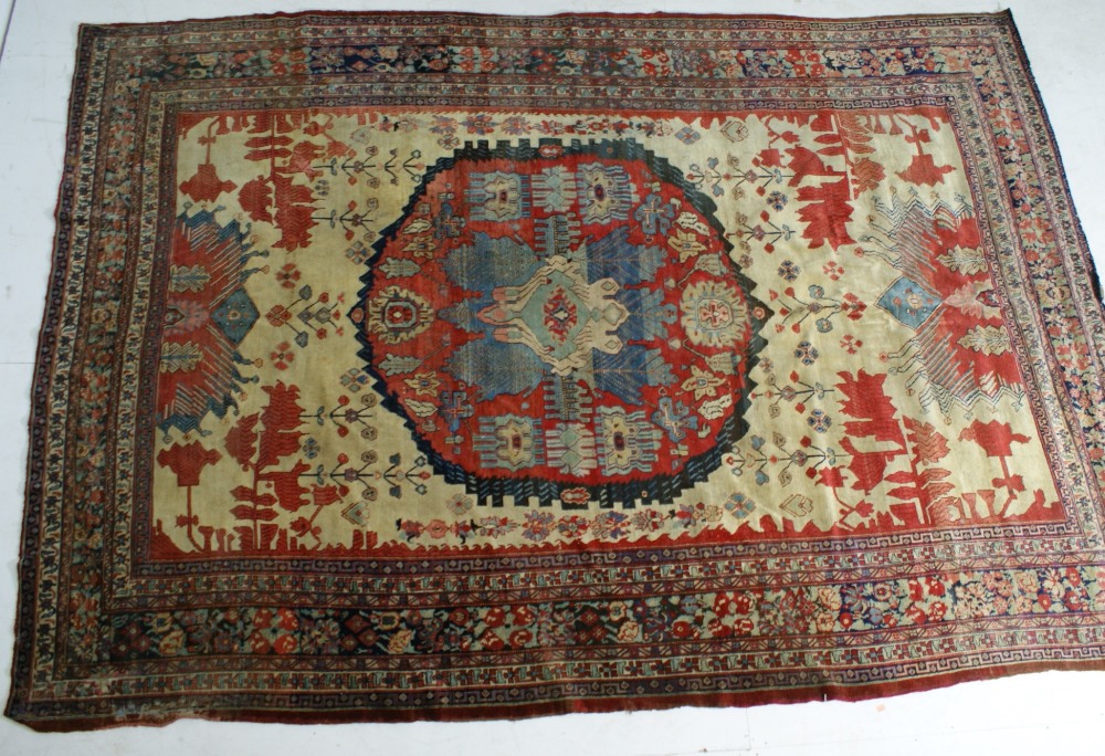 Hamadan woollen carpet, central red medallion against a yellow-fawn ground,
