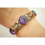 14ct gold and amethyst bangle, set with three large round cut amethysts in an openwork setting,