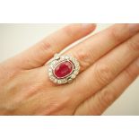 Ruby and diamond cluster ring in 14ct white gold, the central oval cut ruby of approx. 4.