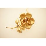 9ct gold rose brooch, formed as a single rose centred with a pearl and a single small sapphire,