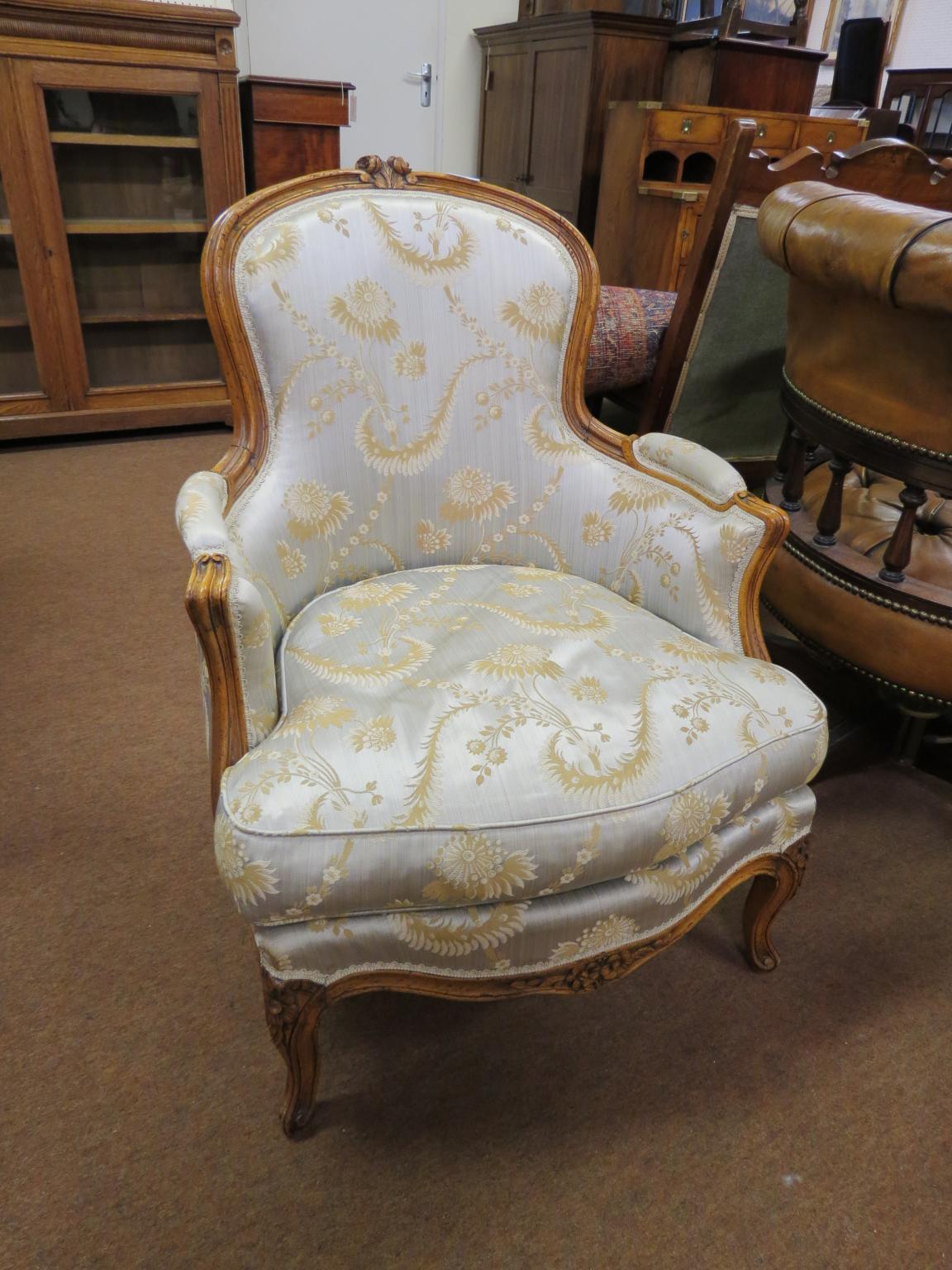 Two Louis XV-style walnut framed elbow chairs, with carved detail, upholstered, on moulded