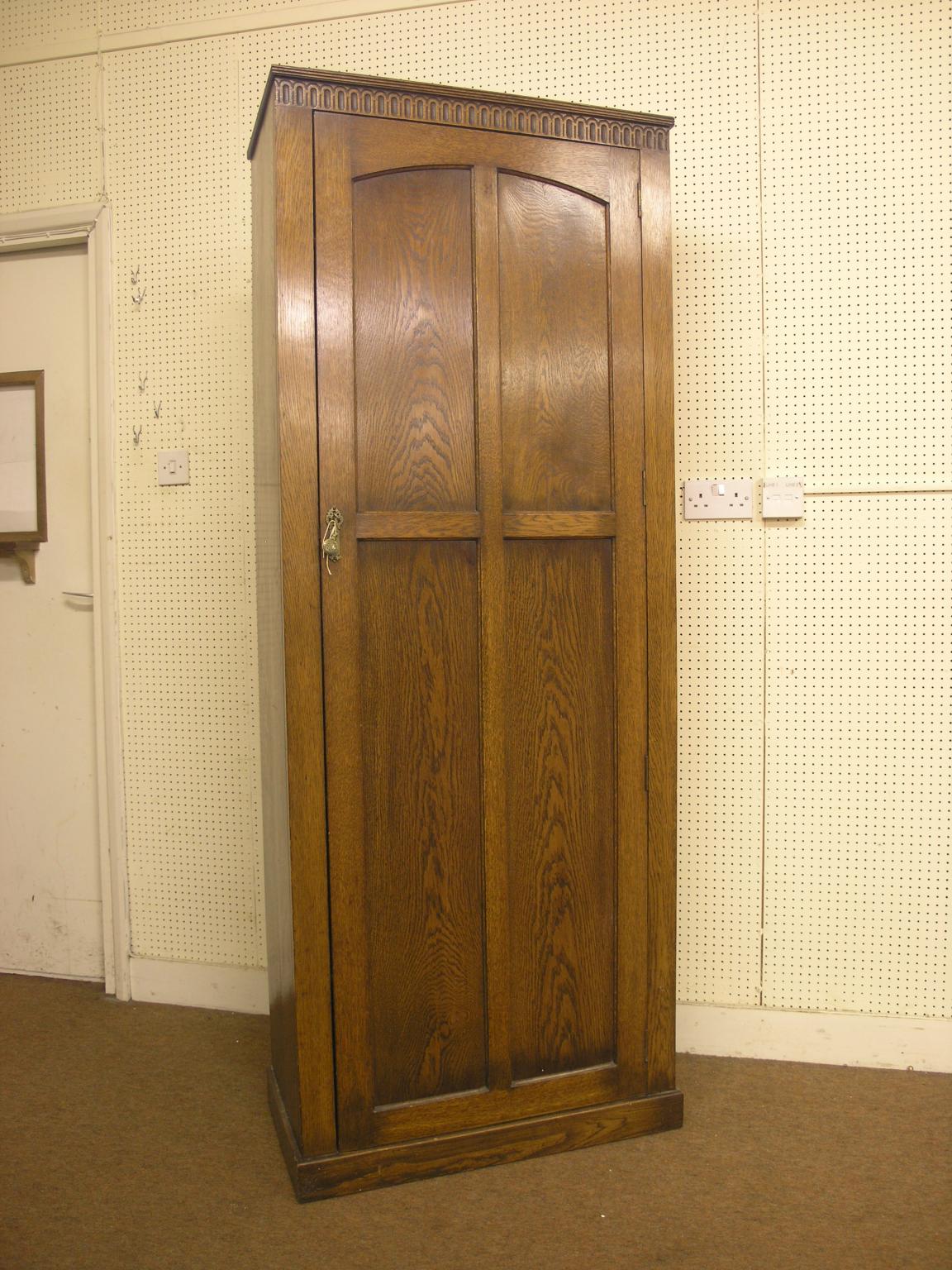 A solid, dark oak hall cupboard, enclosed by single, full-length panelled door, 2ft. 5in. wide