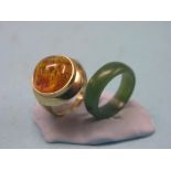 A 14ct. gold and reconstituted amber ring, cushion setting, size L/M, together with a jade ring