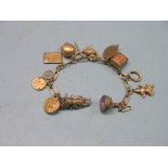 A yellow metal charm bracelet, with 9ct. gold charms, 26.1 grams gross total