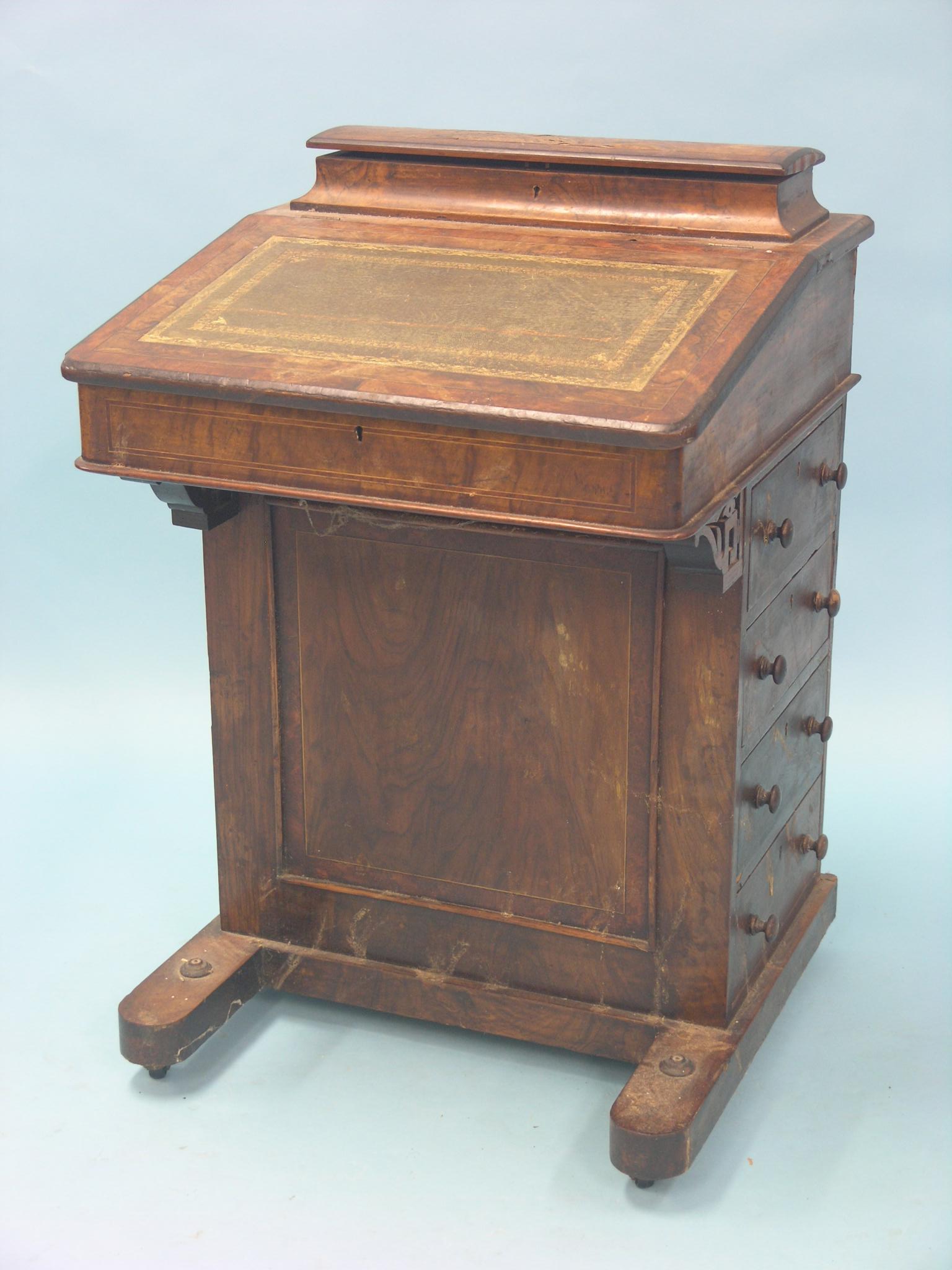 A Victorian walnut Davenport, sloping top with stationery fittings, four side drawers with turned