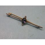 An Art Deco 15ct. gold bar brooch, set single faceted amethyst and four diamond chips