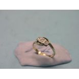 A 1920's 18ct. gold and three-stone diamond cross-over ring, size N/O