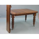 A Victorian walnut dining table, wind-action with two extra leaves, on turned legs with casters,
