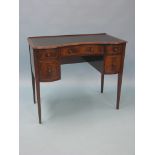 A reproduction inlaid mahogany writing table, concave-shape, inset gilt-tooled leather top above a