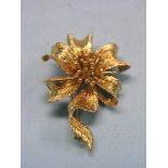 A Kutchinsky 18ct. gold ribbon brooch, textured ribbon leaf design and central stamen, signed,