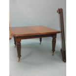 A Victorian extending dining table, with two extra leaves, on reeded, tapering legs with casters,