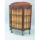 An early 20th century mahogany display cabinet, half-round shape with blind-fret frieze, lined