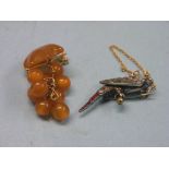 A silver bird brooch, set coloured paste, and a simulated amber brooch with gold mount