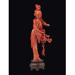 A carved coral figure of Guanyin with grapes and roses, China, early 20th century gr. 99 con base, h