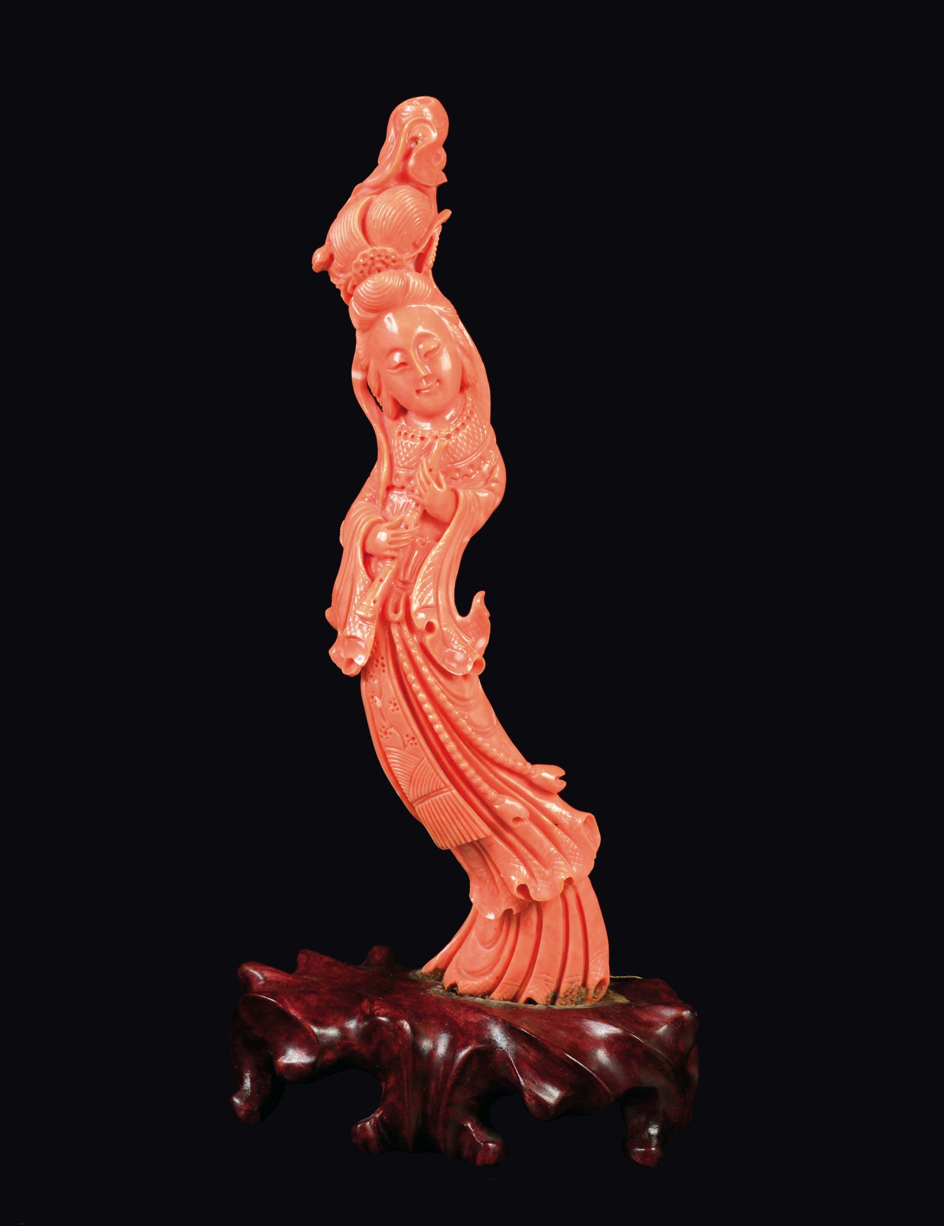 A carved coral figure of Guanyin with flute, China, early 20th century gr 200 circa, h cm 20