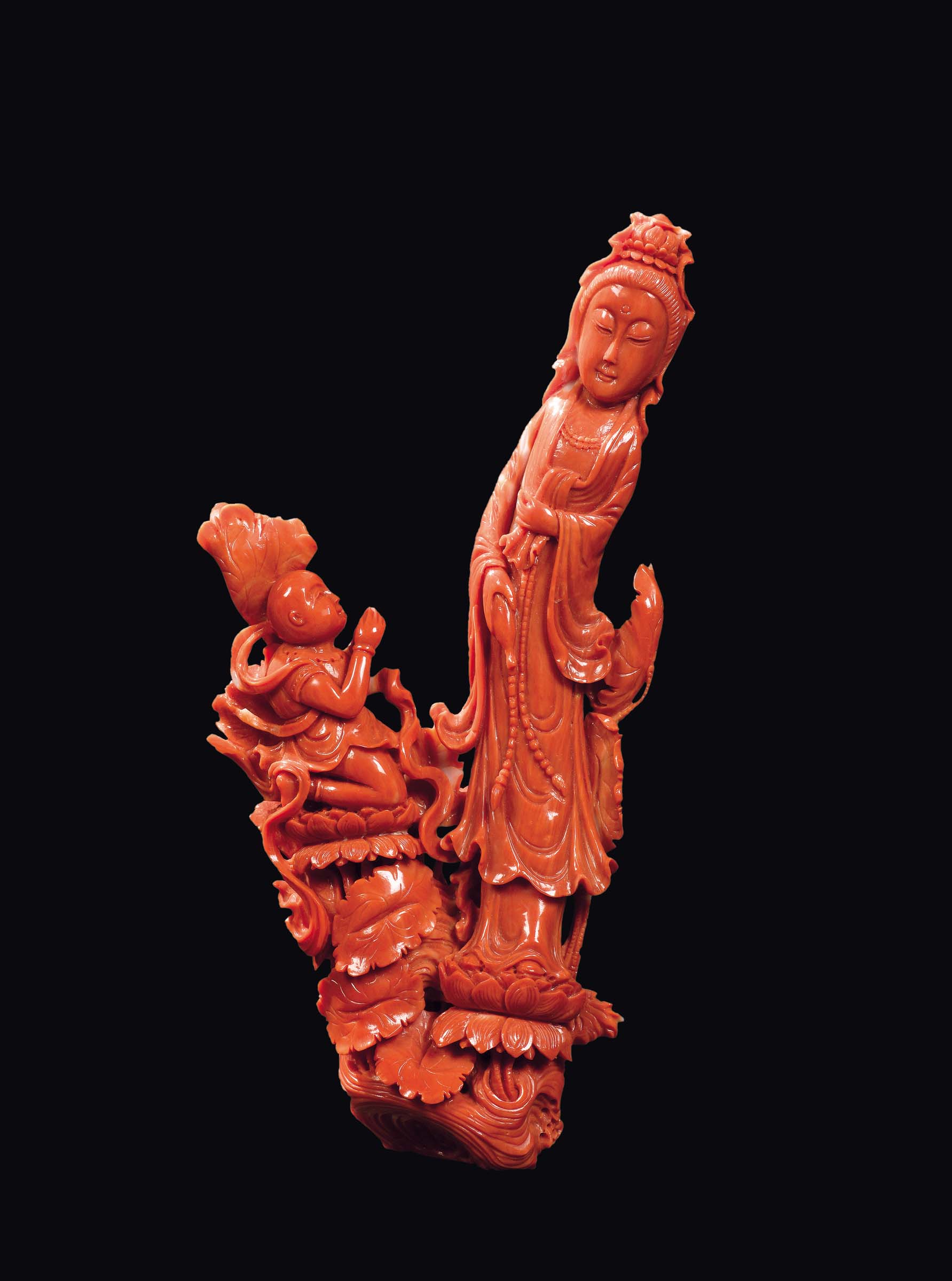 A carved coral "Guanyin with praying child on lotus flowers", China, early 20th century gr. 295, h