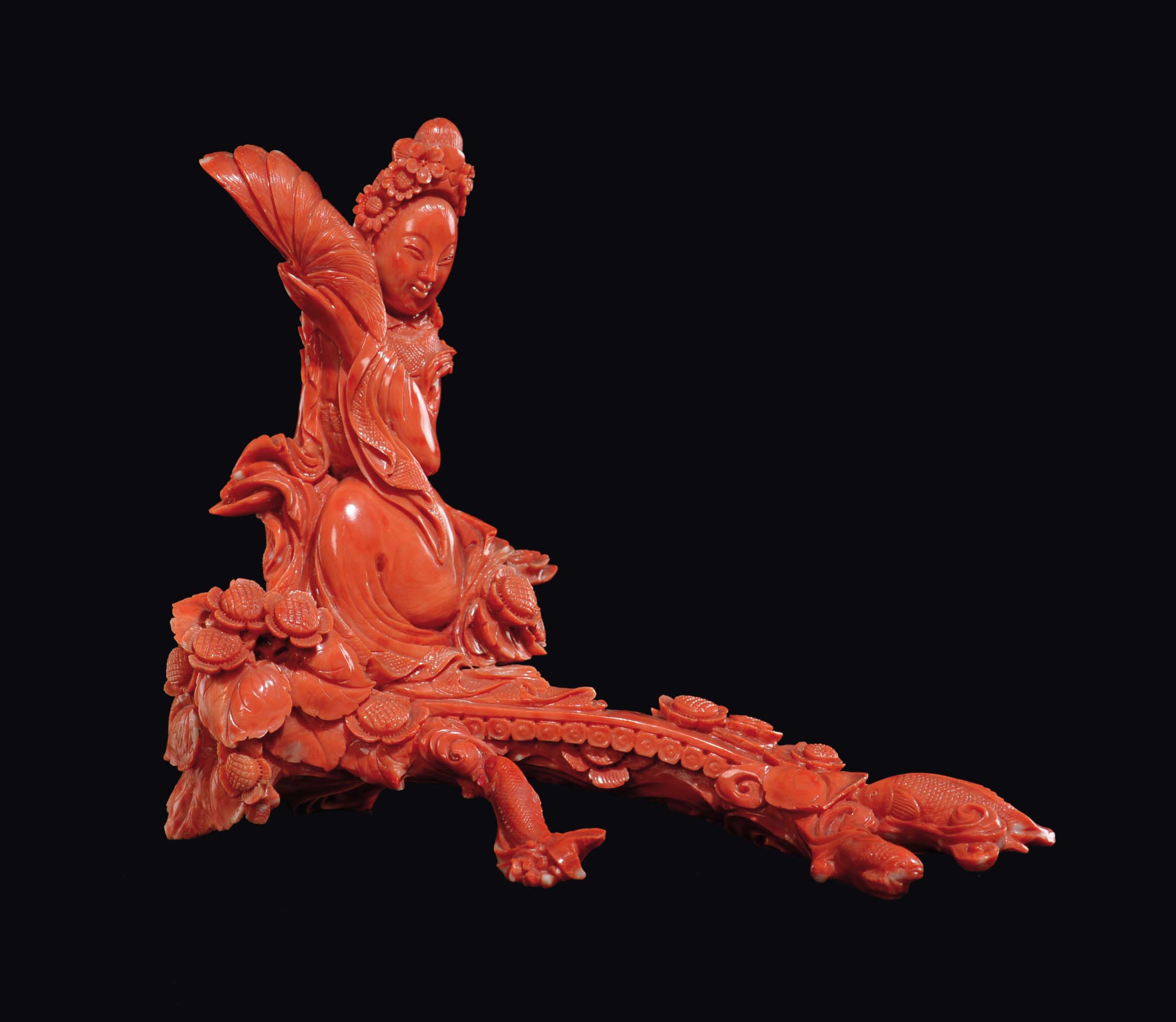 A carved coral "Guanyin with plumed fan on a landing place" group, China, early 20th century gr.
