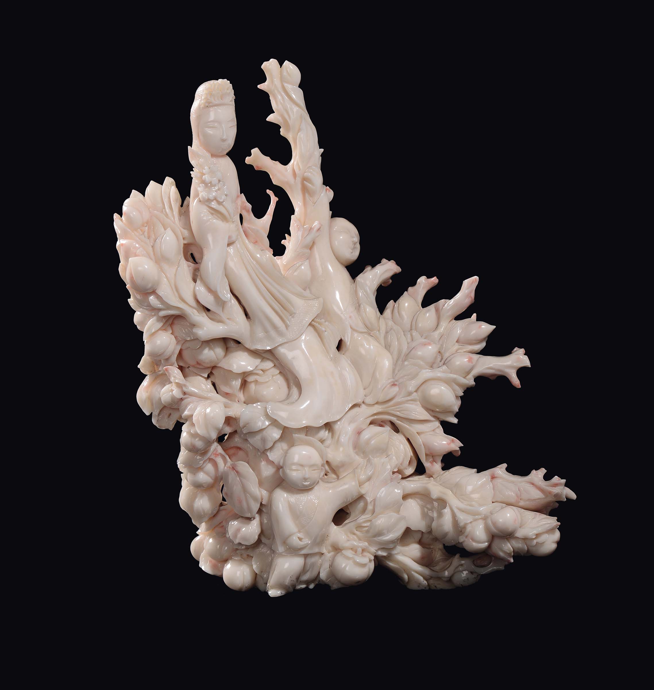 A carved white coral "Guanyin and children between branches and peaches" group, China, early 20th