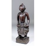 A Burmese or Thai carved hardwood standing figure of a bare chested man holding a club (?), 12ins