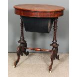 A Victorian rosewood oval work table, the top with matched veneer enclosing fitted interior and with