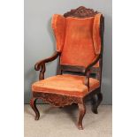 An 18th Century Dutch oak framed wing back open armchair with shaped and curved crest rails, plain