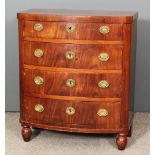 An early 19th Century figured mahogany bow-front commode with angled front corners, fitted four long