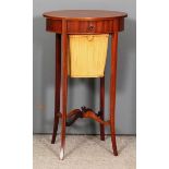 An Edwardian mahogany oval work table of Sheraton design, the top inlaid with oval shell motif,