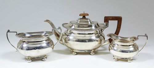 A George V silver rectangular three piece tea service with gadroon mounts, angular loop handles,