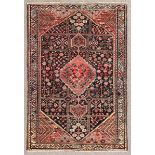 An antique Hamadan rug woven in colours with stepped double headed medallion, confirming spandrels