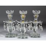 A set of three early 19th Century cut-glass candlesticks with slice, diamond and star cuttings,
