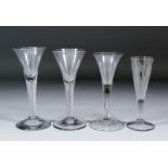 A pair of English 18th Century wine glasses of trumpet form, the plain air twist stems on a plain