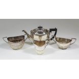 An Edward VII silver three piece tea service with oval part reeded bodies, comprising - teapot, 5.