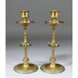 A pair of Victorian brass ecclesiastical candlesticks with drip pans and circular knops with clear