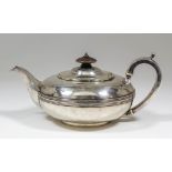 A George III silver circular teapot of bulbous squat form with reeded girdle to body, scroll