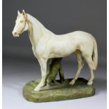 A Royal Dux bone china figure of a standing grey horse, on naturalistically modelled base, 15ins