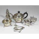 An Edward VII silver circular three piece tea service with shaped rim, on shell capped scroll