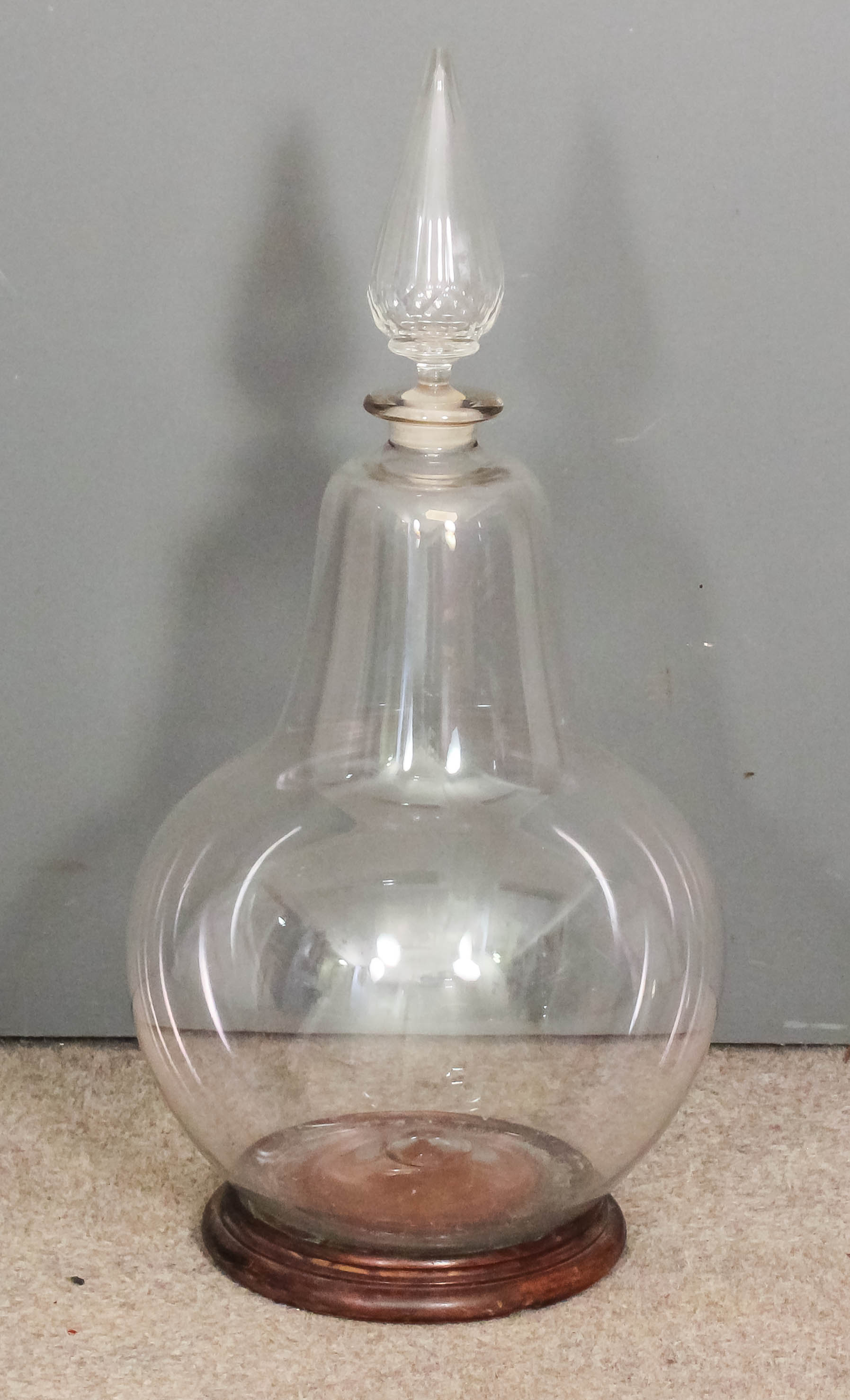 A 19th Century Chemist's clear glass carboy with bulbous body and cut-glass conical stopper, 35ins
