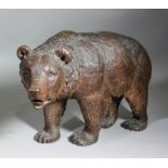 A 19th Century "Black Forest" carved and stained lindenwood figure of a standing bear, 14ins high (