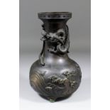 A Japanese bronze bulbous shaped vase, the body cast with a dragon above waves, 10.5ins (267mm) high