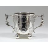 A late Victorian silver two-handled cup inset with Elizabeth I coin, with cast caryatid pattern