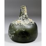 An early 18th Century green glass "Onion" shaped wine bottle with narrow string rim and cone pontil,