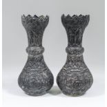 A pair of near Eastern silvery metal baluster shaped vases with knop to stem, the neck embossed with
