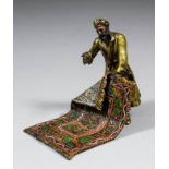 An early 20th Century Austria cold painted bronze figure of an Arab carpet seller, 3.75ins high x