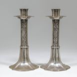 A pair of Edward VII silver pillar candlesticks of Art Nouveau design with shaped oval sconces, cast