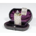 A Victorian silver cylindrical scent bottle and cover engraved and chased with scroll work, 2.