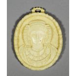 An oval ivory plaque carved with a shoulder-length bust of a woman, her hair elaborately dressed